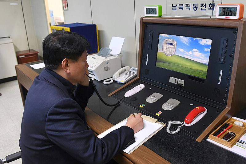 FILE - In this Jan. 3, 2018, file photo released by South Korea Unification Ministry, a South Korean government official communicates with a North Korean officer during a phone call on the dedicated communications hotline at the border village of Panmunjom in Paju, South Korea. North and South Korea on Tuesday, July 27, 2021, have restored suspended communication channels between them and their leaders agreed to improve ties, both governments said Tuesday, despite a two years and a half stalemate in U.S.-led diplomacy aimed at stripping North Korea of its nuclear weapons. (South Korea Unification Ministry/Yonhap via AP, File)