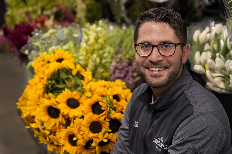 Steven Dyme, owner of Flowers for Dreams, poses for a portrait at his warehouse Friday, July 23, 2021, in Chicago. Dyme says the $15 minimum made it much easier to staff up when the economy reopened this spring and demand for flowers, particularly for weddings, soared. The company has four locations, including its headquarters in Chicago, one in Milwaukee, and two in Detroit. (AP Photo/Charles Rex Arbogast)