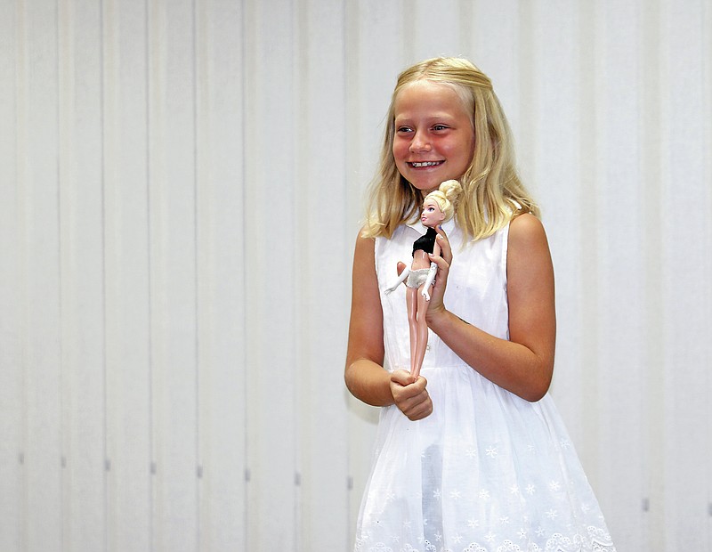 
Adrian Holtgrewe holds a Barbie on Tuesday to show an outfit she made for the doll duing the Fashion Revue contest at Cole County Extension Center. 