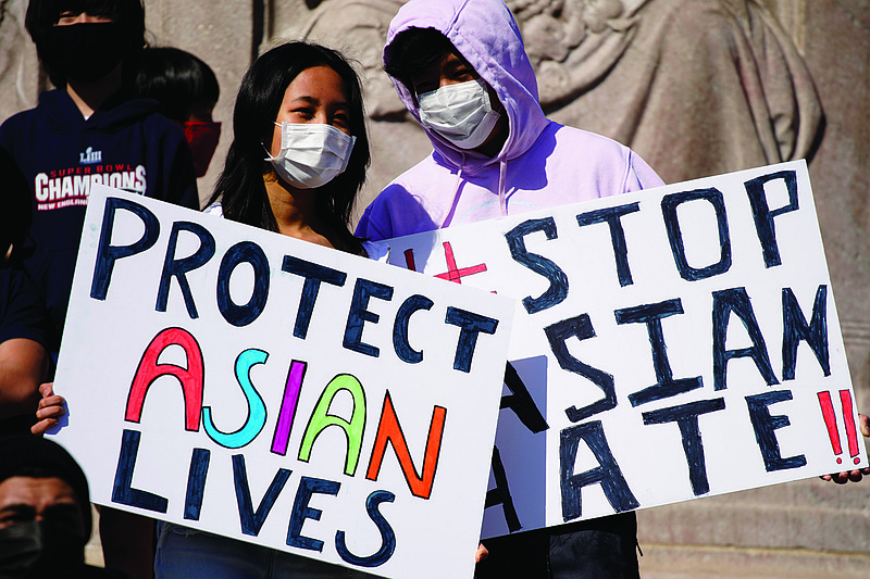 This March 20, 2021, file photo shows people holding signs as they attend a rally to support Stop Asian Hate at the Logan Square Monument in Chicago. A national coalition of civil rights groups will release on Wednesday, July 28, 2021, a comprehensive, state-by-state review of hate crime laws in the United States. Members of the coalition say the report sets the stage for bolstering the efficacy of current law and addresses racial disparities in how the laws are enforced. (AP Photo/Nam Y. Huh, File)