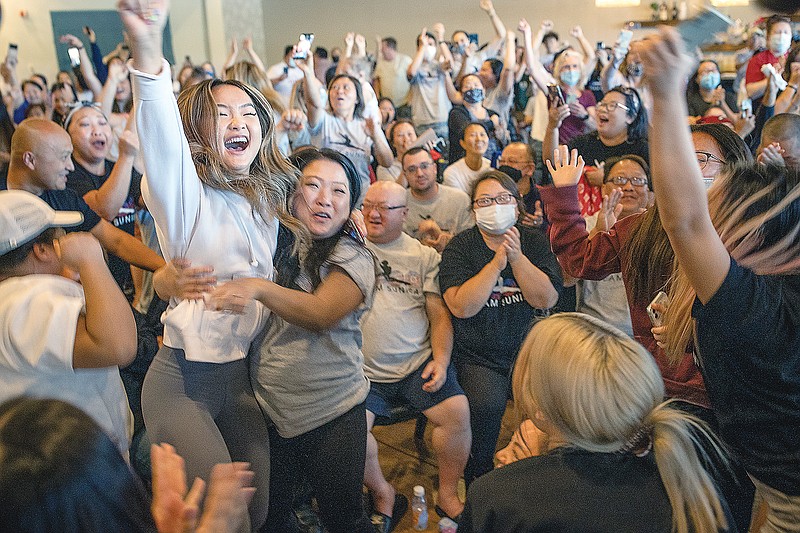 Shyenne Lee (left foreground), the older sister of Olympian Sunisa Lee, reacts alongside Souayee Vang and other family and friends as they watch Sunisa Lee clinch the gold medal Thursday in the women's gymnastics all-around at the 2020 Summer Olympics in Oakdale, Minn.
