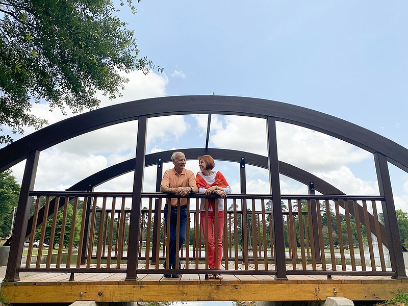 Julie-Ray and John Harrison  stand on a bridge along the walking path at Spring Lake Park in Texarkana Texas.
