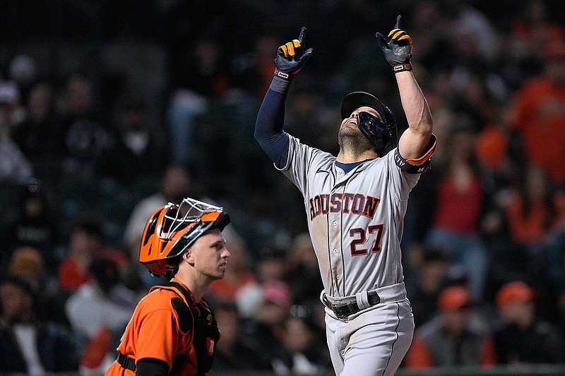 Houston Astros' Jose Altuve points to the sky as he crosses home plate next to San Francisco Giants catcher Buster Posey after hitting a solo home run during the fifth inning of a baseball game Friday, July 30, 2021, in San Francisco. (AP Photo/Tony Avelar)