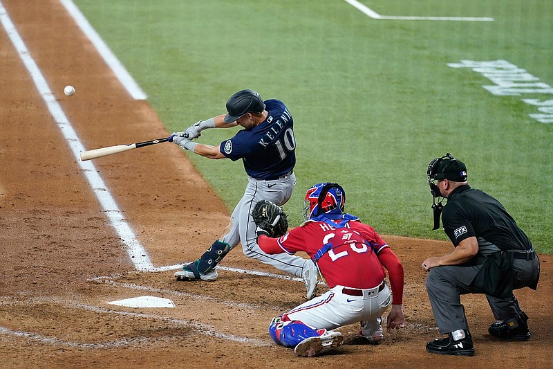 Seattle Mariners' Jarred Kelenic (10) connects for a three-run home run in front ot Texas Rangers' Jonah Heim and umpire Scott Barry during the third inning of a baseball game in Arlington, Texas, Friday, July 30, 2021. (AP Photo/Tony Gutierrez)