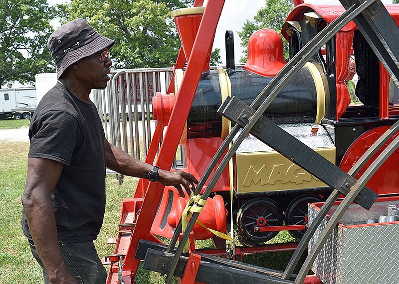 Calvin Clark, a longtime employee with PBJ Happee Days carnival, packs up a train ride on Sunday as the carnival prepares to head to its next show.