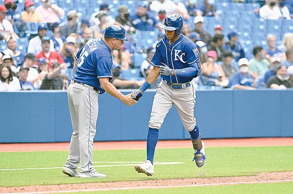 Edward Olivares and Royals third base coach Vance Wilson celebrate his solo home run as Olivares rounds the bases during the ninth inning of Sunday afternoon's game against the Blue Jays in Toronto.