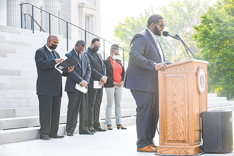 Jason Grace of Jefferson City COGIC delivers the closing prayer of Monday's First Day of School Prayer Initiative. Grace was among a number of area ministers who gathered on the south Capitol steps to offer prayers for teachers, students, administrators and others involved in the education of children. The event was hosted by COPE, Clergy Observing Public Education.