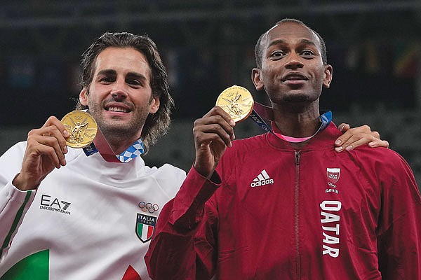 Joint gold medalists Gianmarco Tamberi (left) of Italy and Mutaz Barshim of Qatar pose for following the men's high jump final Monday at the 2020 Summer Olympics in Tokyo.