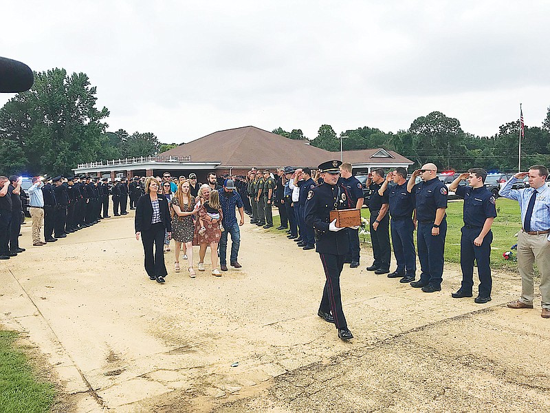  Lt. Clay McClure's family follows an honor guard officer bearing the remains of the veteran police officer. McClure, an officer with the Texarkana Texas Police Department, lost his battle with COVID last Wednesday.