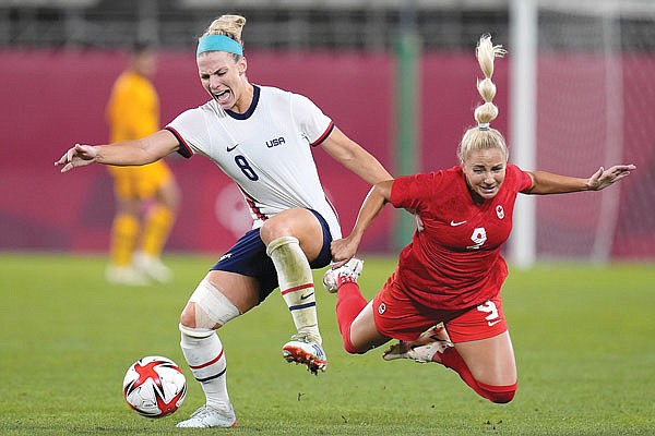 Julie Ertz of the United States battles Canada's Adriana Leon for the ball Monday during a semifinal match at the 2020 Summer Olympics in Kashima, Japan.