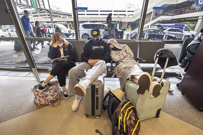 Stranded travelers sleep on the seats of the ticketing waiting area, Tuesday, Aug. 3, 2021. at Philadelphia International Airport in Philadelphia. Their schedule flight to Los Angels was delayed until Thursday, after Spirit canceled nearly half its schedule for Tuesday, the third straight day of extremely high cancellation numbers at the budget airline. (Jose F. Moreno/The Philadelphia Inquirer via AP)