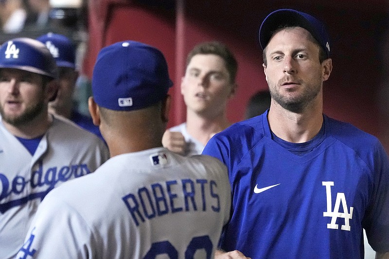 Max Scherzer talks to Dodgers manager Dave Roberts in the dugout before Saturday's game against the Diamondbacks in Phoenix.