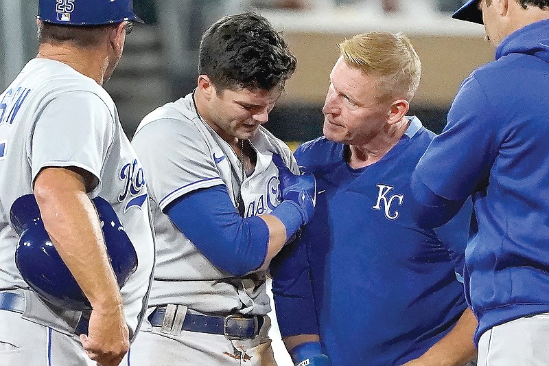 Andrew Benintendi holds his left shoulder and is checked by a member of the Royals training staff after stealing second base during the fourth inning of Tuesday night's game against the White Sox in Chicago.