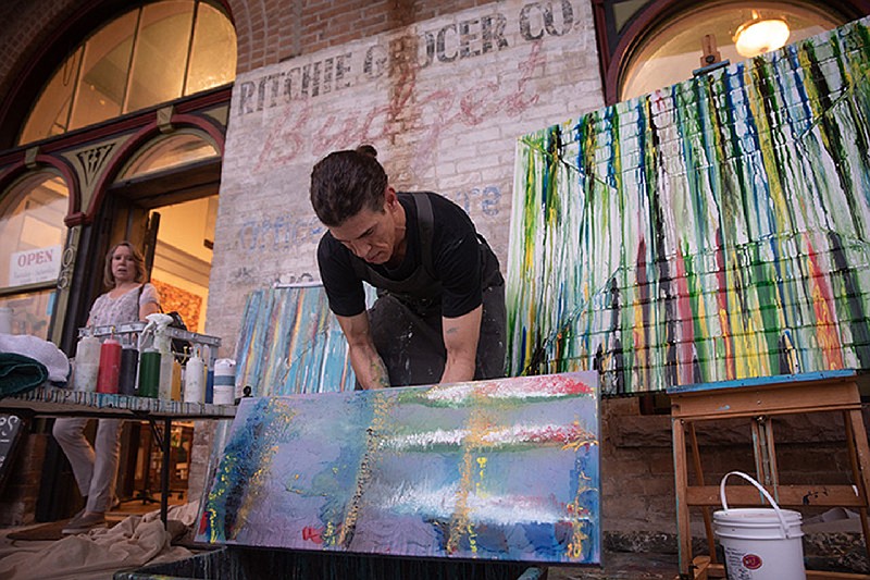 Artist Christopher Bachers lets paint drip from his canvas during the first Downtown Live event this year (Gazette file photo)
.