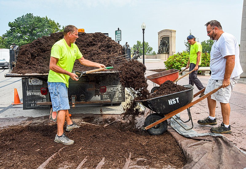 Perry Siebeneck loads mulch into wheelbarrows Friday for co-workers, Derick Coots, right, and Jake Otto to spread around trees and plants on the Missouri Capitol's north side. Facilities Management crews have been busy in recent weeks making sure that the grounds are in top shape going into next week's Missouri Bicentennial celebrations in and around the Capitol.