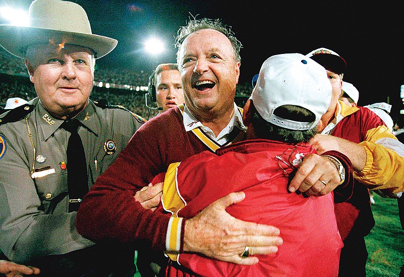 In this Jan. 1, 1994, file photo, Florida State football coach Bobby Bowden (center) receives a congratulatory hug after the Seminoles defeated Nebraska 18-16 in the Orange Bowl in Miami.