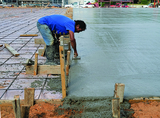 Alfredo Olalde of Foster Concrete Inc. works Friday on smoothing freshly poured concrete at a construction site in the 500 block of Texas Boulevard. The site is across the street from Southern Athletics Baseball Academy and is the future home of Wacha Resolution Sports Training.