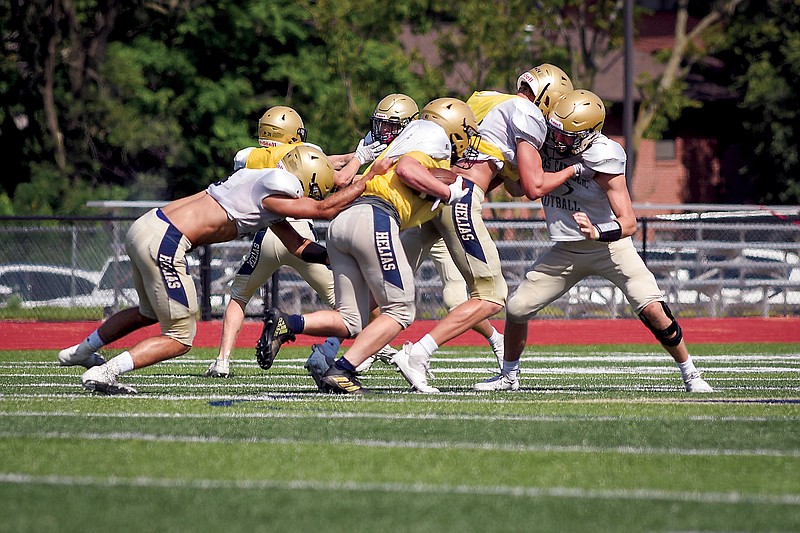 The Helias Crusaders run a play during Saturday morning's scrimmage at Ray Hentges Stadium.