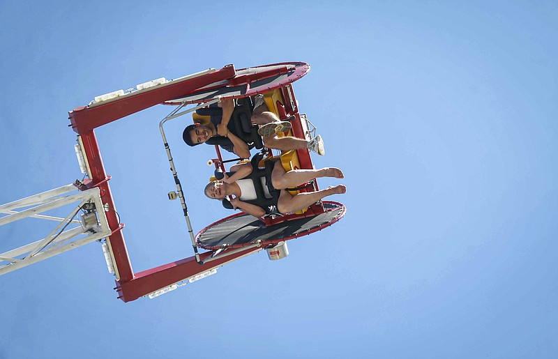 Angela Hodges and Jordan Thomas of Des Moines ride the Skyscraper, one of two thrill rides at the Iowa State Fair on Saturday, Aug. 14, 2021, in Des Moines, Iowa. (Bryon Houlgrave/The Des Moines Register via AP)