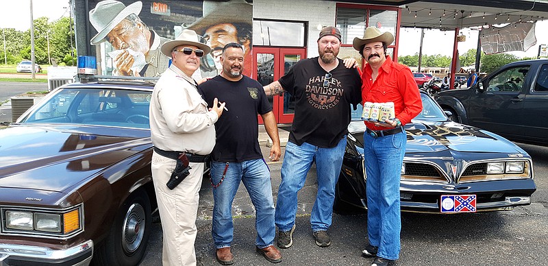 From left, Sean Bailey, portraying Sheriff Buford T. Justice, Jay Hernandez, Bryan Ogburn, and Tim Phillips, portraying Bandit, pose for a photo Friday at Smoke Point restaurant in Texarkana, Texas.