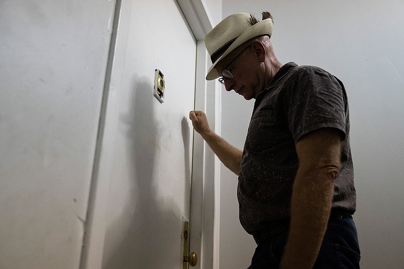 Gary Zaremba knocks on an apartment door as he checks in with tenants to discuss building maintenance at one of his at properties, Thursday, Aug. 12, 2021, in the Queens borough of New York. Landlords say they have suffered financially due to various state, local and federal moratoriums in place since last year. "Without rent, we're out of business," said Zaremba. (AP Photo/John Minchillo)