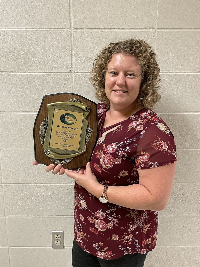 <p>Eugene High School agriculture teacher Bethany Prenger stands with the plaque she received from the Missouri Vocational Agriculture Teachers Association for being named the state winner of the “Ideas Unlimited Award.” Photo courtesy of Prenger.</p>