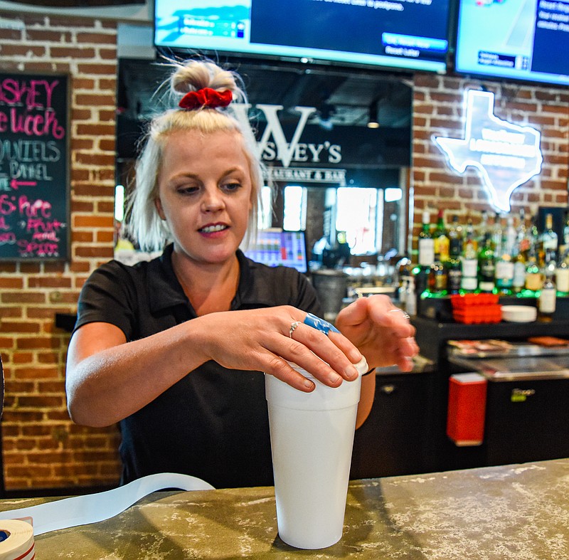 Julie Smith/News Tribune
Sarah Osborne prepares a drink to go Thursday at Big Whiskey's. Missouri's new law on permanent to-go alcohol sales and extended hours for alcohol sales on Sundays takes effect this weekend.