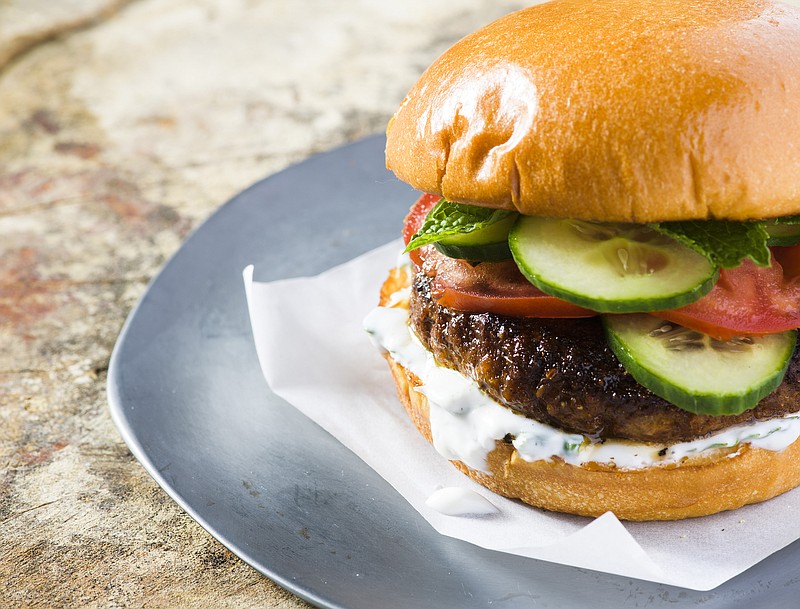 This image released by Milk Street shows a recipe for Indian-spiced pork burgers. The garam masala, cayenne and cumin first are mixed into a paste made from tangy yogurt, egg yolk and breadcrumbs, which helps the burgers stay moist. Mixing the spiced paste into the meat ensures the flavor is distributed evenly throughout each burger. (Milk Street via AP)