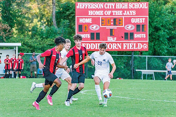 Clayton Hamler of Capital City dribbles the ball against the defense of Jefferson City teammates Deandreis White (left) and Tate Riley during Tuesday night's game at the 179 Soccer Park.
