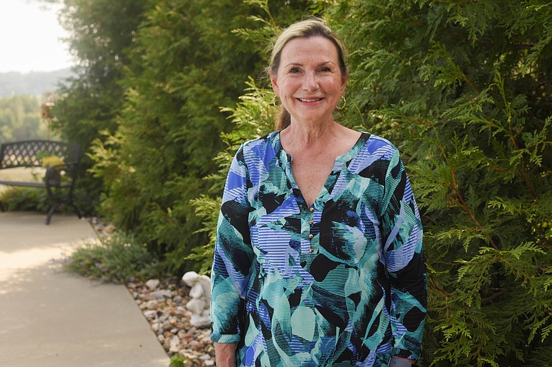 Cassandra Bates stands Aug. 20 in front of the wall of green giant arborvitae trees she planted in her backyard at 518 Boonville Road. Bates is a big collector of trees and said these green gians provide a full wall for privacy from neighbors.