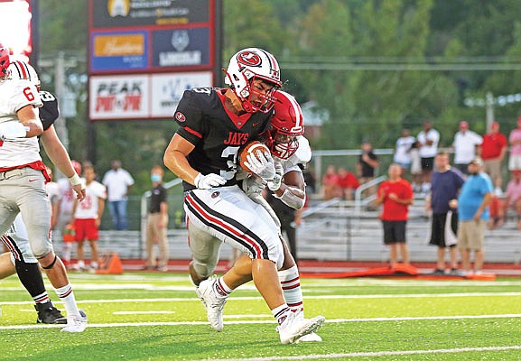 Jefferson City running back Jacob Wilson takes a hit from Chaminade defensive back Cam Epps as he scores a touchdown during last Friday night's at Adkins Stadium.
