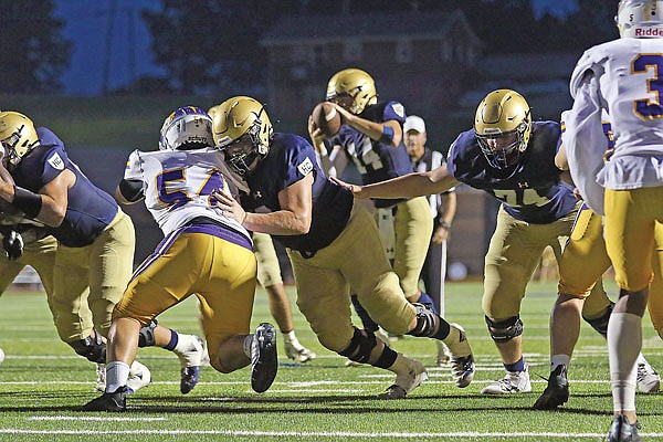 Helias offensive lineman Alex Cook blocks Hickman's Anthony Prach as Helias lineman Trevor Kolb (right) looks for someone to block Friday night at Ray Hentges Stadium.
