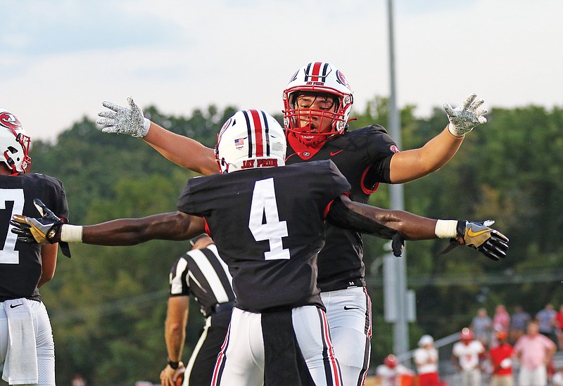 Jefferson City running back Jacob Wilson hugs teammate David Bethune (4) after scoring a touchdown during Friday night's game against Chaminade at Adkins Stadium.