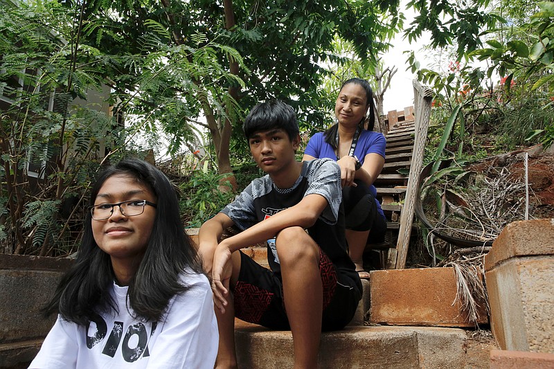 Mary Taboniar, right, a housekeeper at the Hilton Hawaiian Village resort in Honolulu, sits with her children, Mark Daniel Taboniar, 13, and Ma Dennise Taboniar, 12, at their home in Waipahu, Hawaii, Saturday, Sept. 4, 2021. Taboniar went 15 months without a paycheck, thanks to the COVID pandemic. The single mother of two saw her income completely vanish as the virus devastated the hospitality industry. Taboniar is one of millions of Americans for whom Labor Day 2021 represents a perilous crossroads. (AP Photo/Caleb Jones)