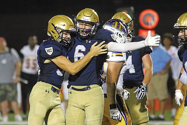 Sam Hentges hugs Helias teammate Carson Brauner after Brauner intercepted a pass during Friday night's game against Hickman at Ray Hentges Stadium.