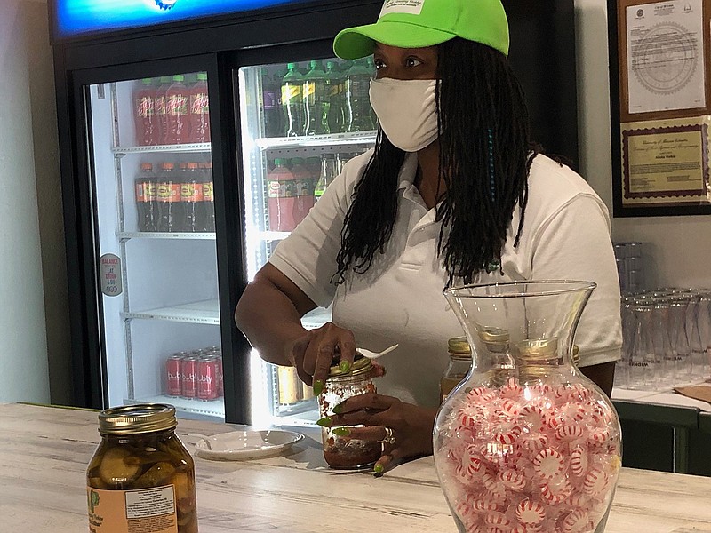 Aliska Walker offers a sample of Ms. Resilient Red Hot Pickle Relish to a customer at her store, Aliska's Amazing Pickles. (Daniel Neman/St. Louis Post-Dispatch/TNS)