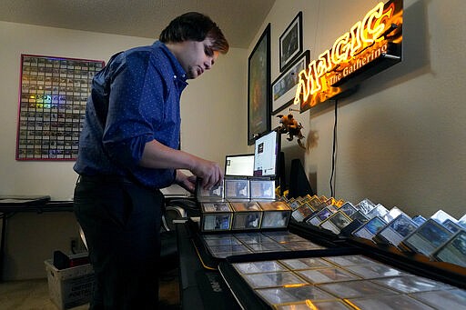 Austin Deceder sorts Magic cards in his home office Friday, Aug. 27, 2021, in Kansas City, Mo. Prices of the collectable cards and vintage video games that Deceder and others buy and sell have skyrocketed in the past few months to the dismay of hobbyists. (AP Photo/Charlie Riedel)