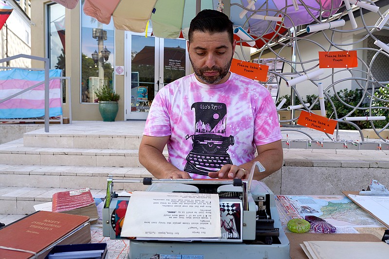 Poet-for-hire Giovanni Cerro of St. Petersburg writes poetry for passing guests for free thanks to a sponsorship by Katee Tully of Smith and Associates during the St. Pete Pride celebration on Beach Drive in June in St. Petersburg, Florida. (Luis Santana/Tampa Bay Times/TNS)