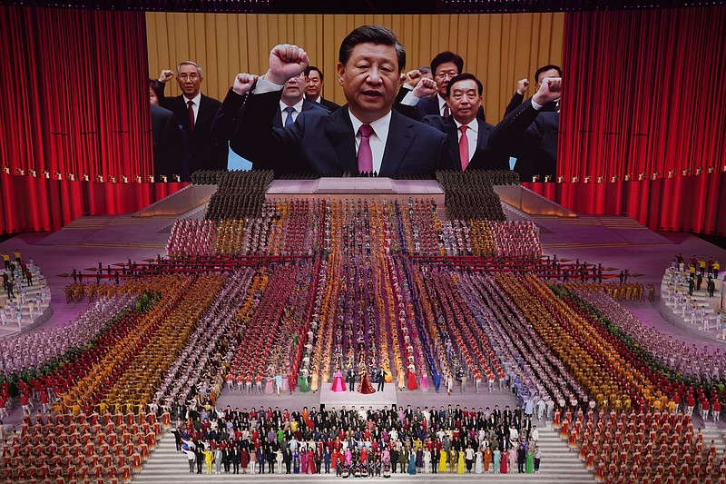 FILE - In this June 28, 2021, file photo, Chinese President Xi Jinping is seen leading other top officials pledging their vows to the party on screen during a gala show ahead of the 100th anniversary of the founding of the Chinese Communist Party in Beijing. An avalanche of changes launched by China's ruling Communist Party has jolted everyone from tech billionaires to school kids. Behind them: Xi's vision of reviving an idealized early era of vigorous party leadership, with more economic equality and tighter control over society and billionaire entrepreneurs. (AP Photo/Ng Han Guan, File)