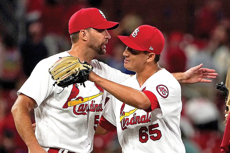 Giovanny Gallegos (right) and Cardinals teammate Adam Wainwright celebrate Wednesday after a 5-4 victory against the Dodgers at Busch Stadium in St. Louis.