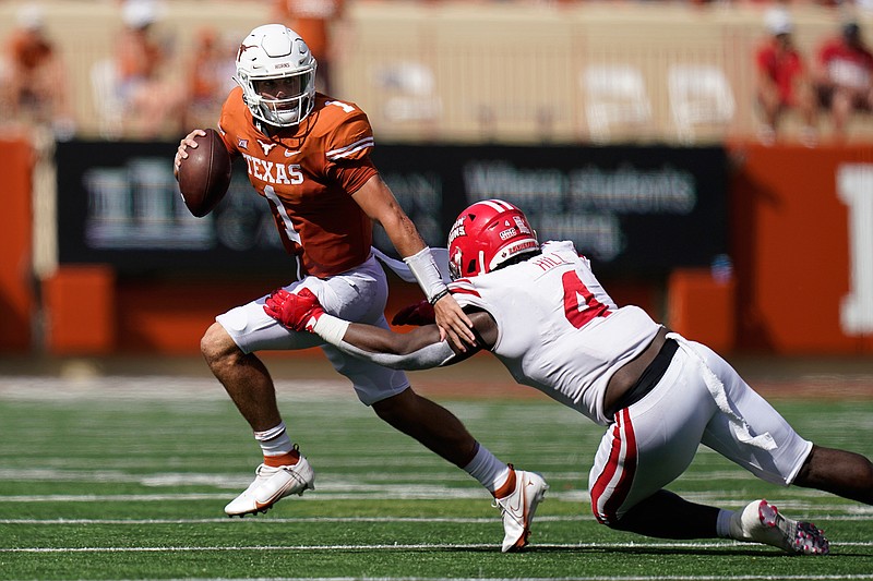 Texas quarterback Hudson Card (1) is pressured by Louisiana-Lafayette defensive lineman Zi'Yon Hill (4) during the first half of an NCAA college football game, Saturday, Sept. 4, 2021, in Austin, Texas. (AP Photo/Eric Gay)