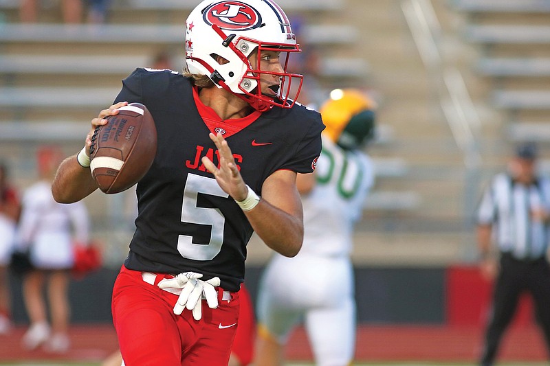 Jefferson City quarterback Hayden Wells searches for a receiver to throw to during Friday night's game against Rock Bridge at Adkins Stadium.