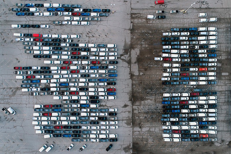 In this March 24, 2021 file photo, mid-sized pickup trucks and full-size vans are seen in a parking lot outside a General Motors assembly plant where they are produced in Wentzville, Mo. The global shortage of computer chips is getting worse, forcing automakers to temporarily close factories including those that build popular pickup trucks. General Motors announced Thursday, Sept, 2, 2021 that it would pause production at seven North American plants during the next two weeks, including two that make the company's top-selling Chevrolet Silverado pickup. (AP Photo/Jeff Roberson, File)