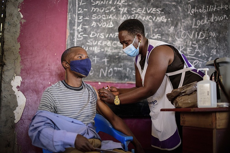 A nurse administers a coronavirus vaccination at Kisenyi Health Center in downtown Kampala, Uganda Wednesday, Sept. 8, 2021. Uganda is accelerating its vaccination drive in order to administer 128,000 doses that recently arrived and expire at the end of September. (AP Photo/Nicholas Bamulanzeki)