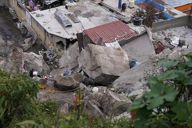 Boulders that plunged from a mountainside rests among homes in Tlalnepantla, on the outskirts of Mexico City, when a mountain gave way on Friday, Sept. 10, 2021.  A section of mountain on the outskirts of Mexico City gave way Friday, plunging rocks the size of small homes onto a densely populated neighborhood and leaving at least one person dead and 10 others missing. (AP Photo/Eduardo Verdugo)