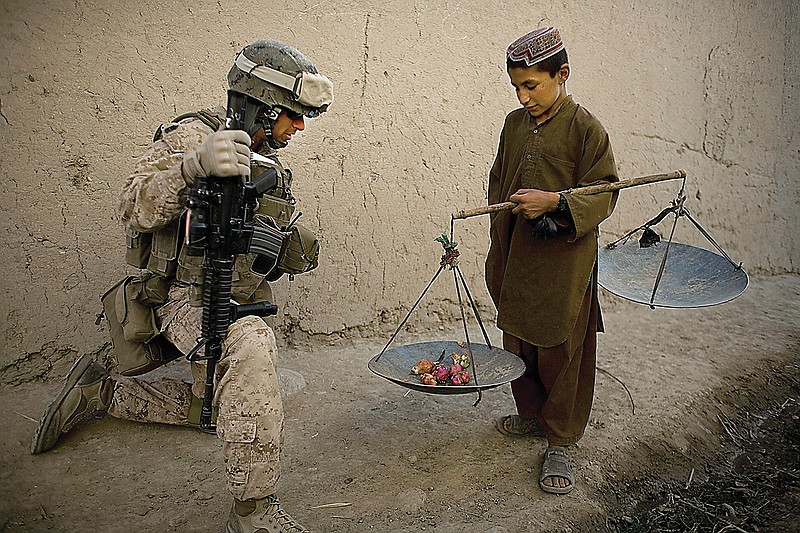 FILE - In this Nov. 3, 2010 file photo, First Sgt. Yomen English, of Brookland, Ark., with India company, 3rd Battalion 5th Marines, First Marine Division, talks to a boy during a patrol, in Sangin, Afghanistan. (AP Photo/Dusan Vranic, File)
