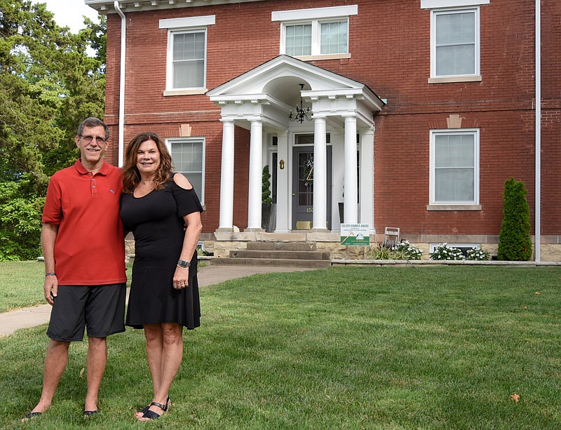 Gary and Sherri Zenishek pose in front of their Jefferson City home at 1508 W. Main St., where many months of hard work have earned the family a Golden Hammer Award and a warm and inviting place to live.