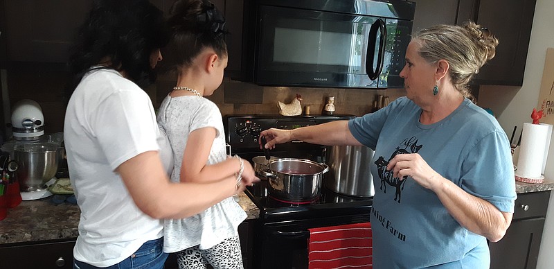 Debbie Binning, right, demonstrates jelly making to a kitchen full of students, including Honey Young, left, and Starlet Boswel, Honey's granddaughter. The Binnings want to pass on their farm knowledge and have found a steady flow of students willing to learn.