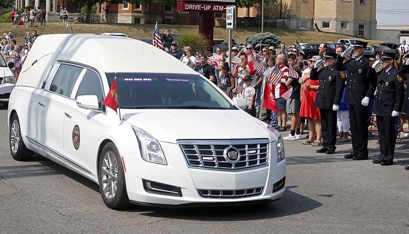 A hearse carrying the body of Marine Corps Cpl. Humberto Sanchez pauses during his funeral procession on Sunday, Sept. 12, 2021, in Logansport, Ind. Sanchez was among 13 U.S. service members killed in a suicide bombing during the U.S.-run evacuation at Afghanistan’s Kabul airport on Aug. 26. (Christine Tannous /The Indianapolis Star via AP)