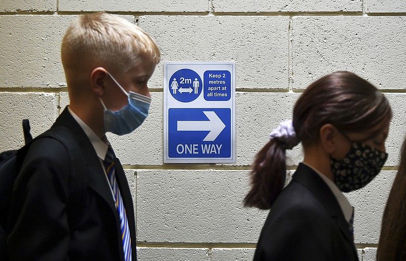 FILE - In this Friday, Sept. 3, 2021 file photo, pupils at Covid test station as they entered their new secondary school for the first time at Wales High school, Sheffield, England. Britain’s chief medical officers say children ages 12 to 15 should be vaccinated against the coronavirus. England Chief Medical Officer Chris Whitty and his counterparts in Scotland, Wales and Northern Ireland, said Monday, Sept. 13 that the age group should be given a single dose of the Pfizer-BioNTech vaccine.  (AP Photo/Rui Vieira, file)